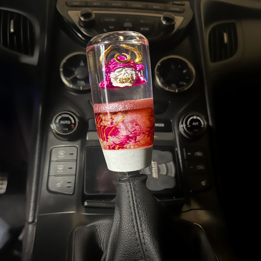 Cyberpunk Oni Samurai Shift Knob – custom resin gear shift with pink helmet, gold horns, and handcrafted Japanese demon detail.