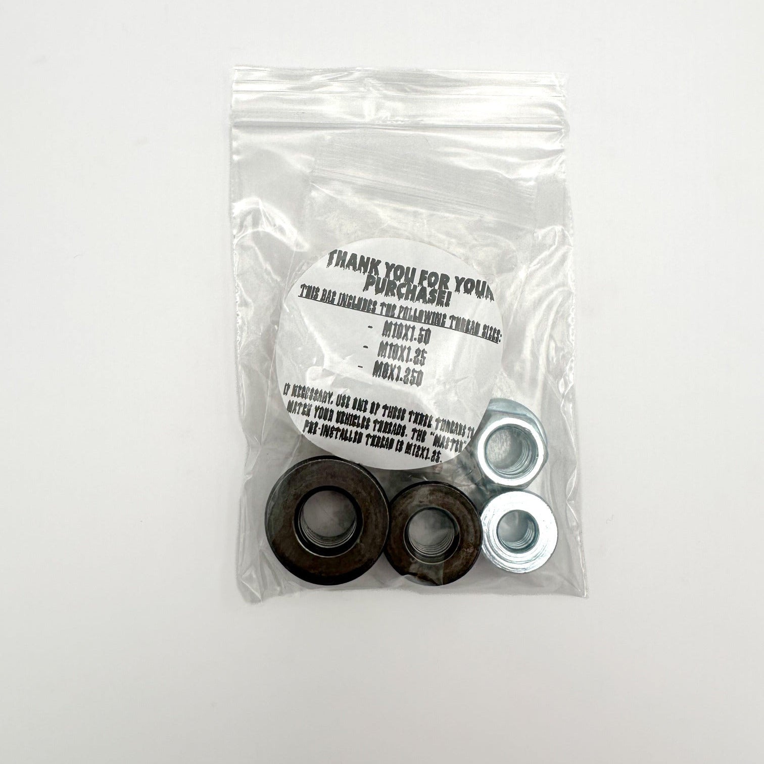 clear plastic bag holding 4 flange nuts to match the 4 thread sizes that come with shift knob. smaller bag in big bag with bushings. 