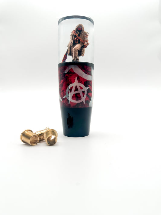 Bold resin shift knob featuring a masked figure with a barbed wire bat and anarchy symbols. Weighted for smooth shifting. Fits most manual and automatic cars.



