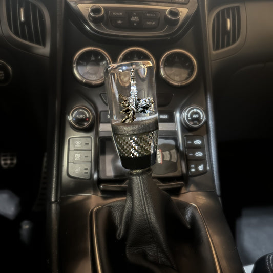 custom shift knob with cupid and ak-47 with carbon fiber and black accents for weighted universal fit on manual cars.