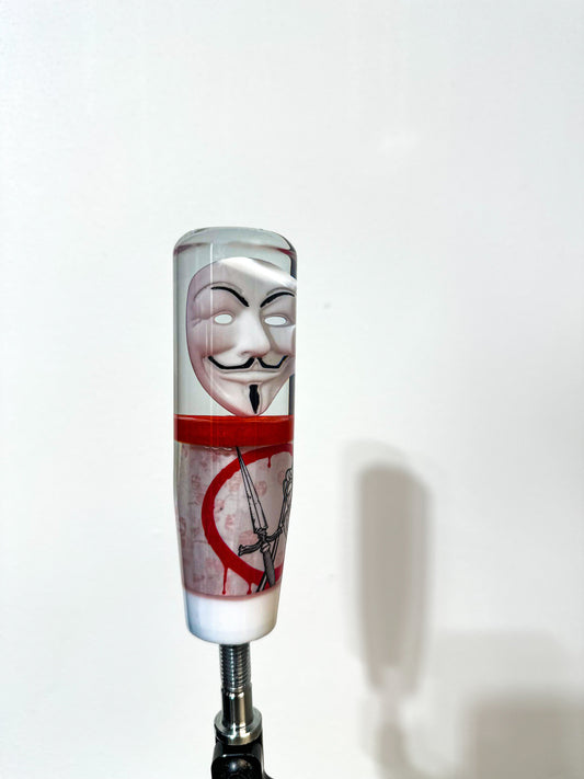 Guy Fawkes mask shift knob made by nice knob, bro. an American shift knob company. Shifter transitions from Fawkes mask to red layer, followed by v for vendetta inspired design. dead rose crossed with dagger on bloody circle. in background a legion of anonymous. final layer white. great universal stick shifter weighted for cars. 